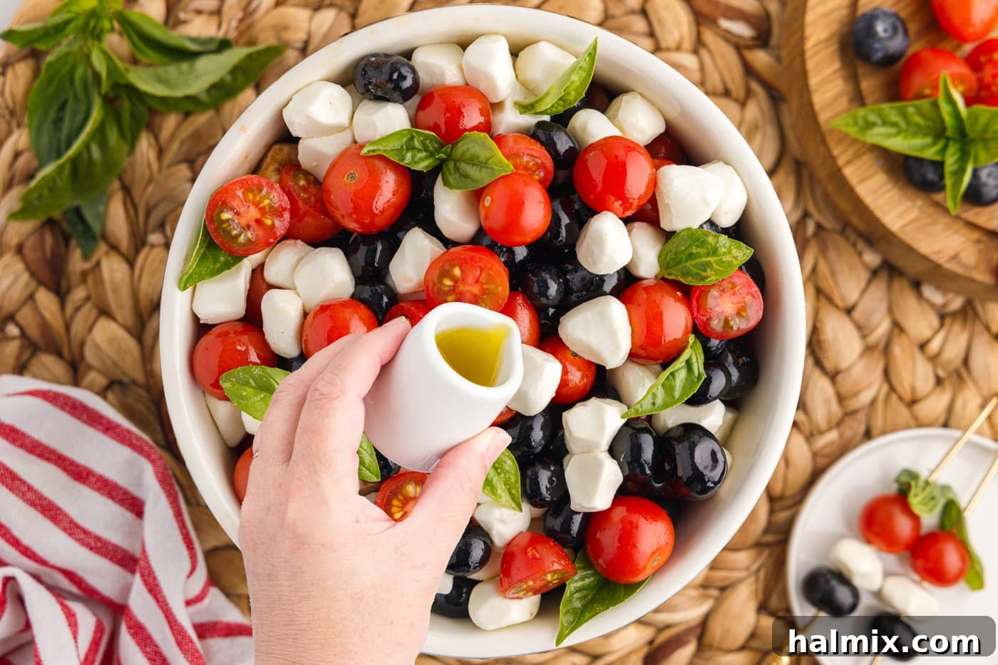 drizzling balsamic glaze over patriotic caprese salad