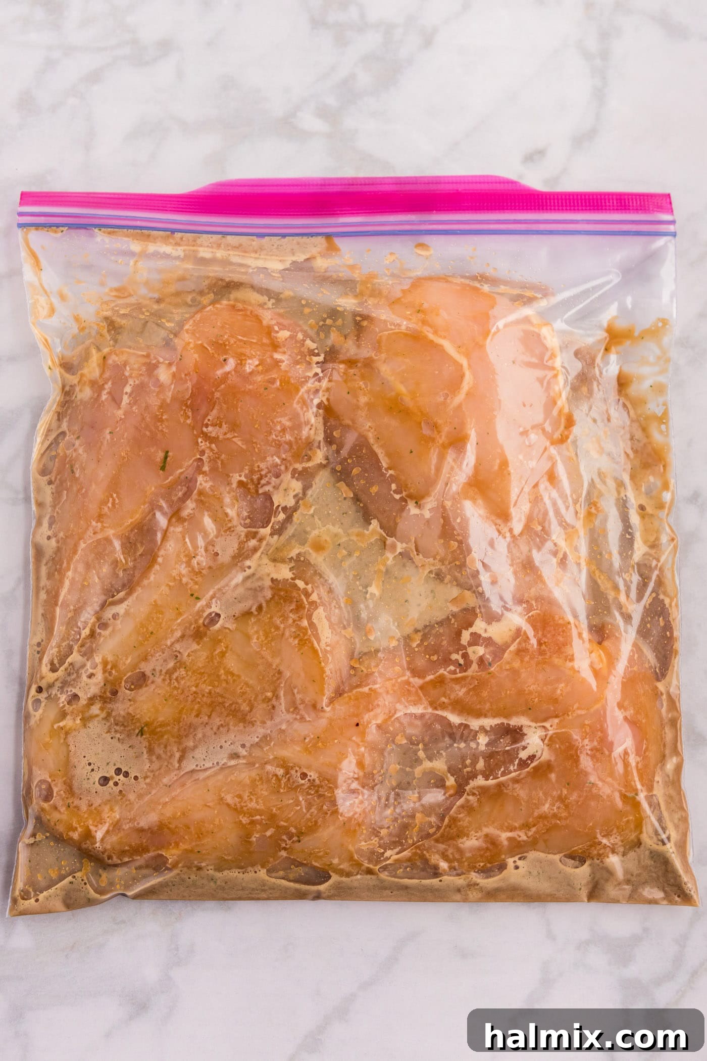 Chicken breasts marinating in a zip-top bag with honey-garlic-soy sauce.