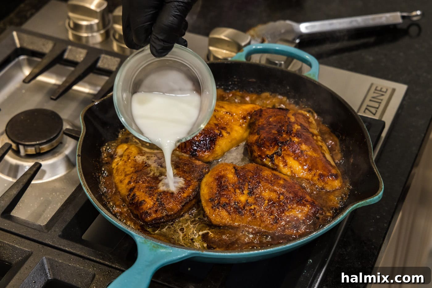 Adding cornstarch slurry to the chicken and sauce in a skillet to thicken.