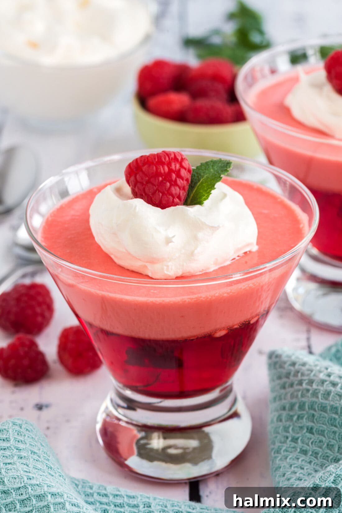 Ruby Raspberry Cream Stacks 13 Raspberry Jell-O Parfaits with a raspberry garnish, ready to be served