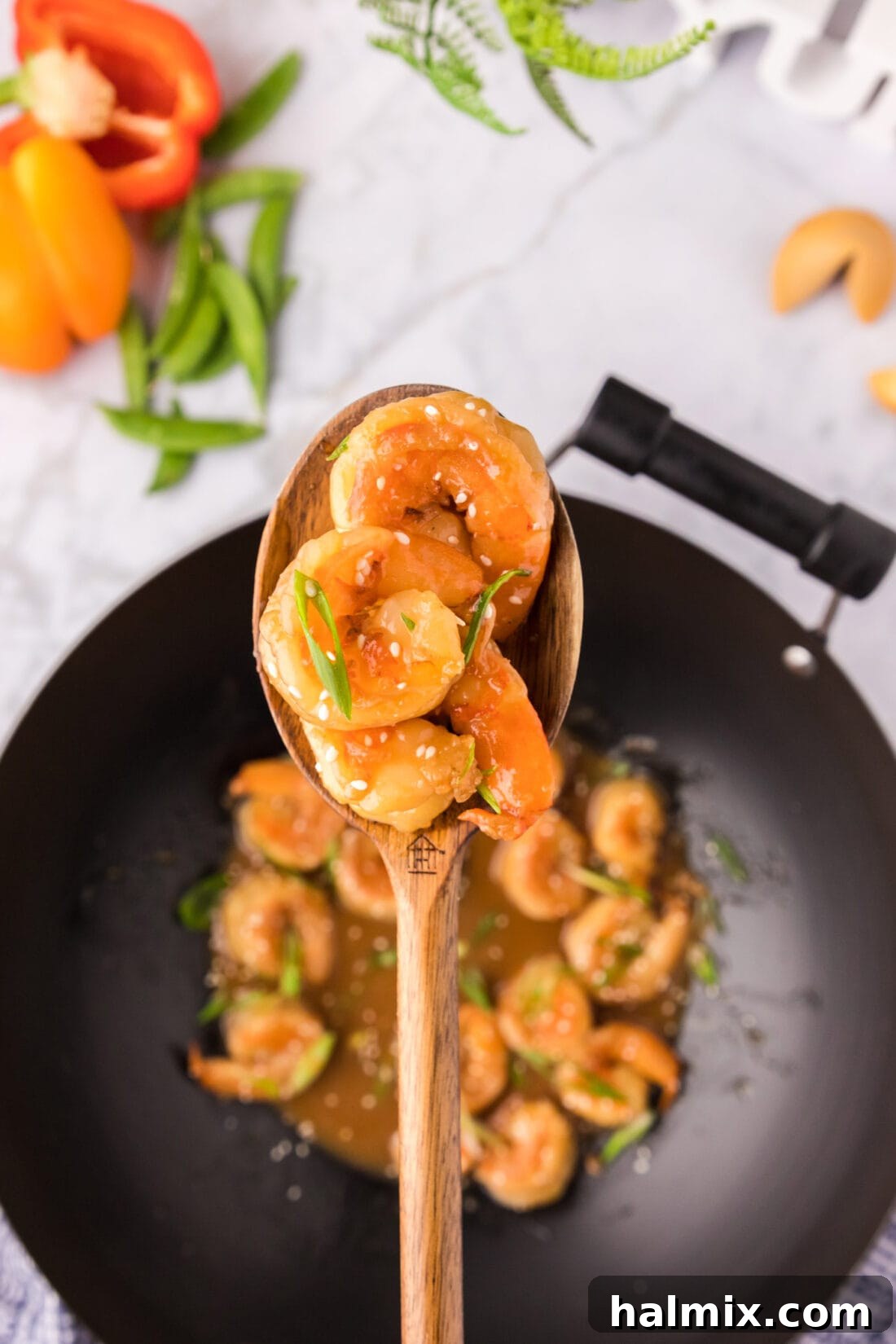 Sticky Teriyaki Shrimp 2 Spoonful of Teriyaki Shrimp held above a wok, showcasing its glossy, rich sauce.