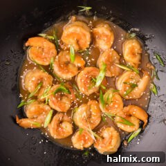 Sticky Teriyaki Shrimp 11 Close up photo of Teriyaki Shrimp in a wok, showing the glossy sauce and perfectly cooked shrimp.