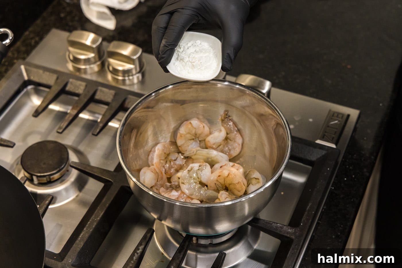 Sticky Teriyaki Shrimp 5 Shrimp being tossed with cornstarch in a large bowl, preparing them for stir-frying.