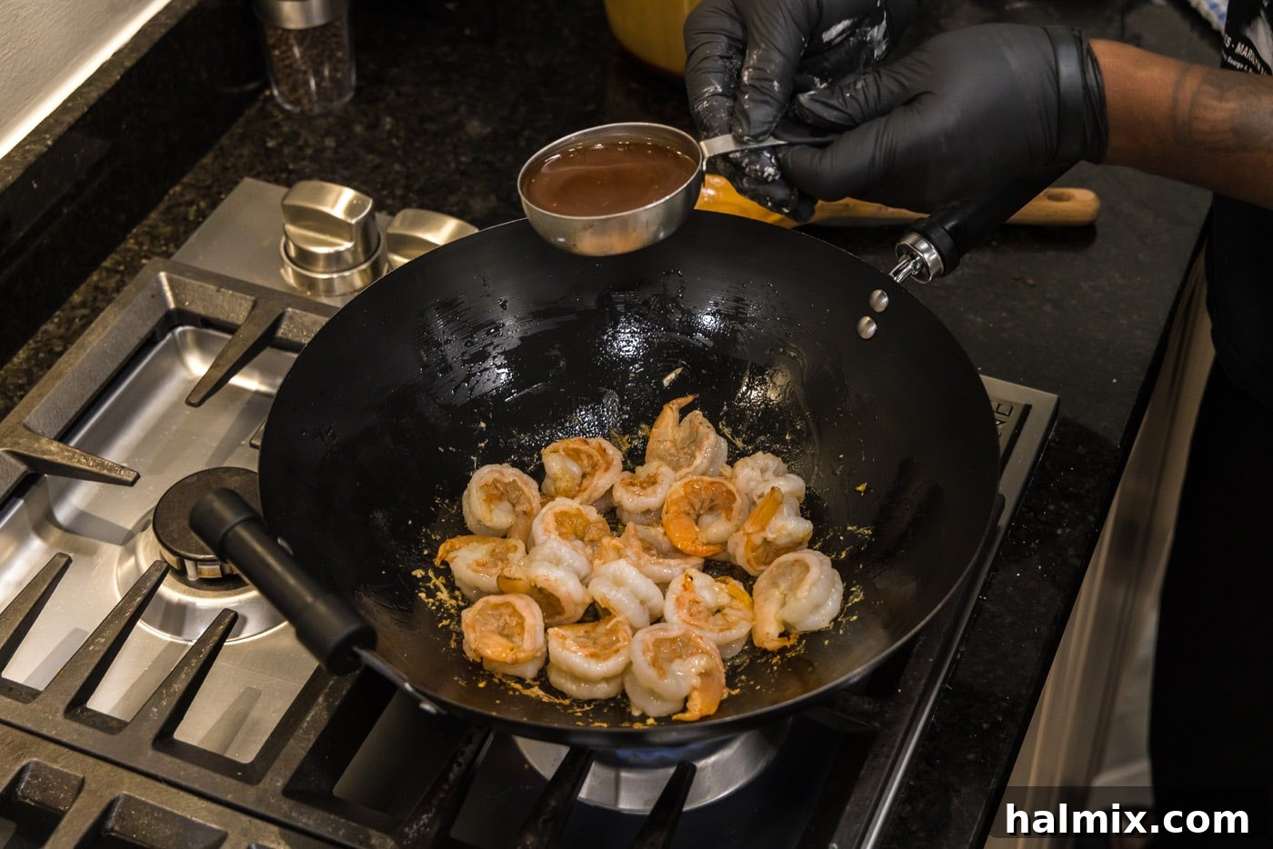 Sticky Teriyaki Shrimp 8 Teriyaki sauce being poured over the cooked shrimp in the skillet, ready to be combined.