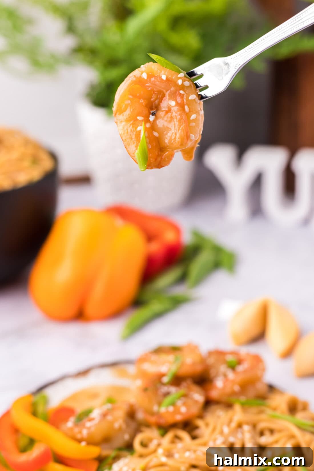 Sticky Teriyaki Shrimp 10 A single piece of perfectly glazed Teriyaki Shrimp held delicately on a fork, ready to be enjoyed.