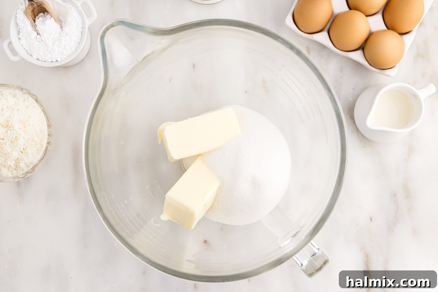 Softened butter and granulated sugar being creamed together in a large mixing bowl, creating a light and fluffy mixture.