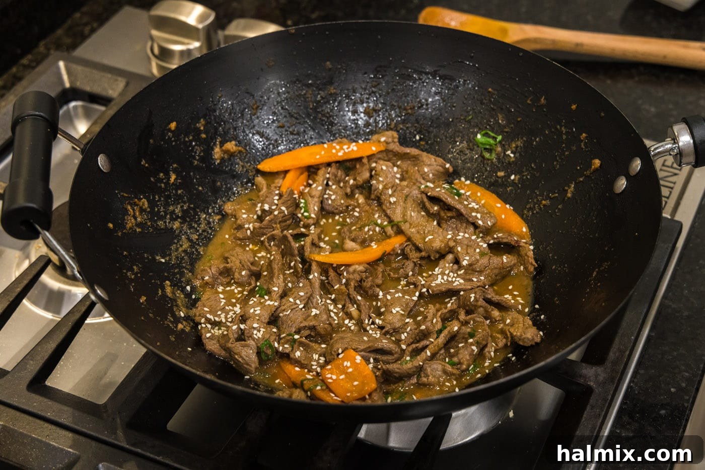 Finished beef bulgogi in a wok, garnished with green onions and sesame seeds, ready to serve.