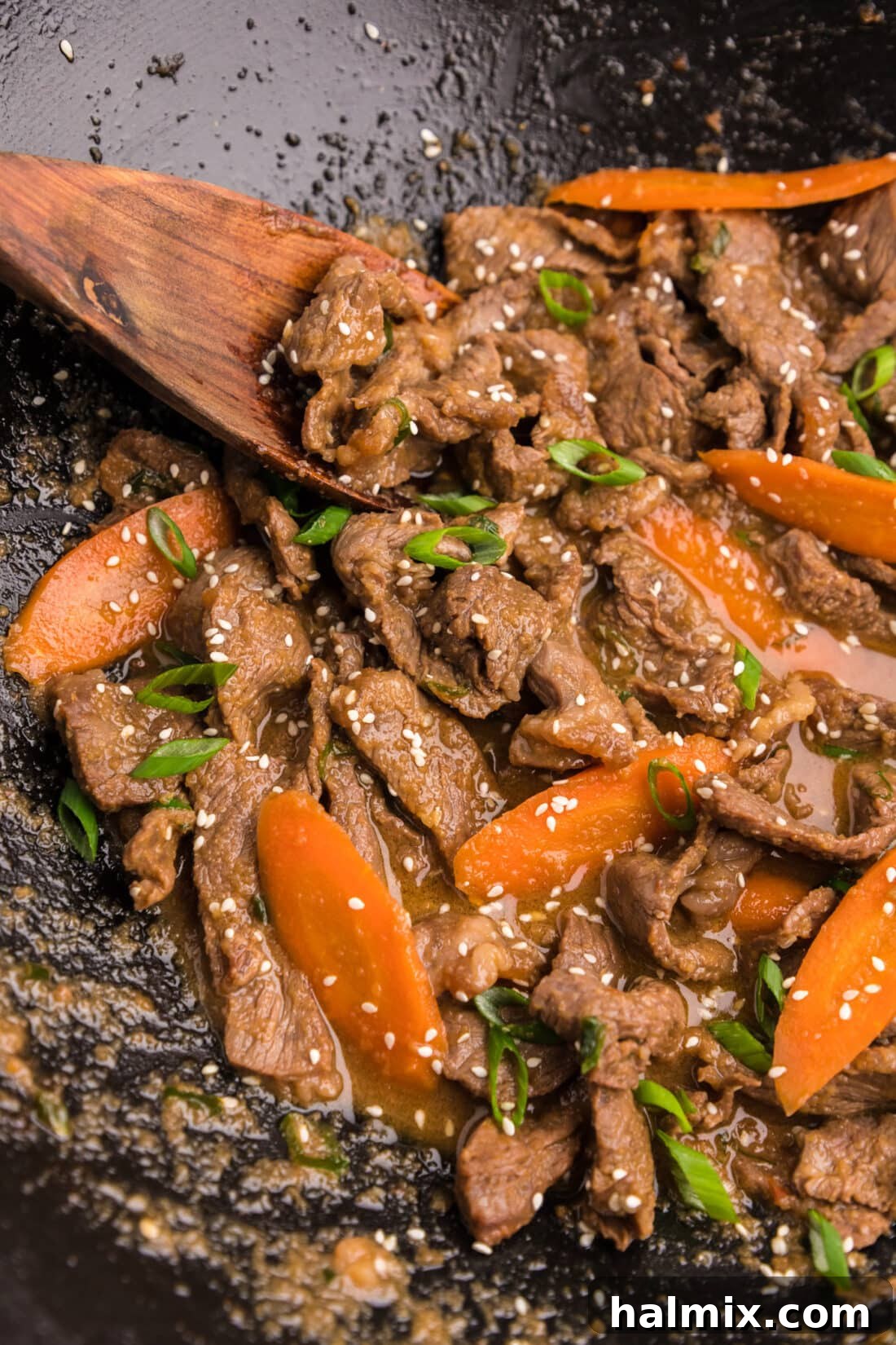 Close-up view of succulent Beef Bulgogi sizzling in a wok, with vibrant vegetables.
