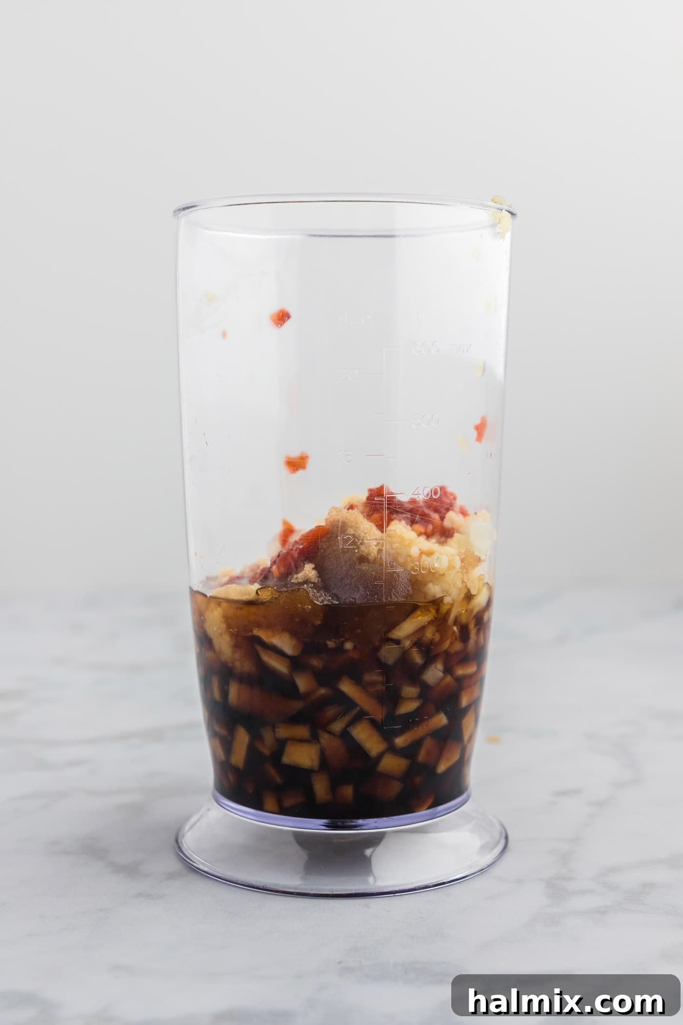 Close-up of fresh bulgogi marinade ingredients in a blender cup, ready for processing.