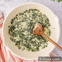 Skillet of Creamed Spinach with a spoon in it
