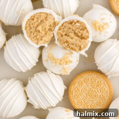 Close up photo of a Golden Oreo Truffle cut in half resting on top of more Golden Oreo Truffles