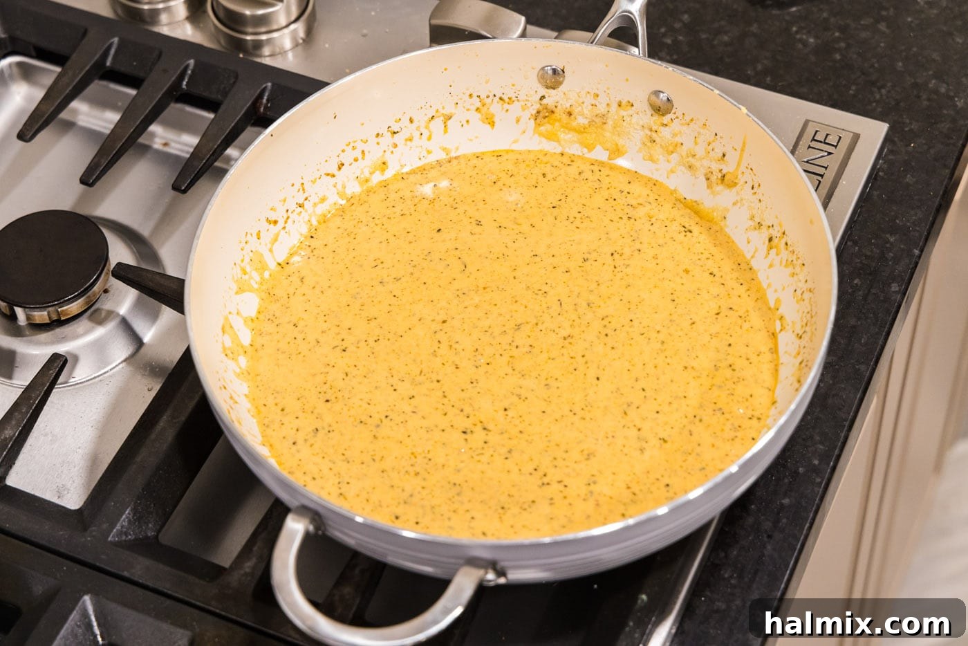 Creamy Garlic Shrimp Alfredo 11 A luscious, smooth homemade Alfredo sauce simmering gently in a skillet, perfectly thickened and ready.