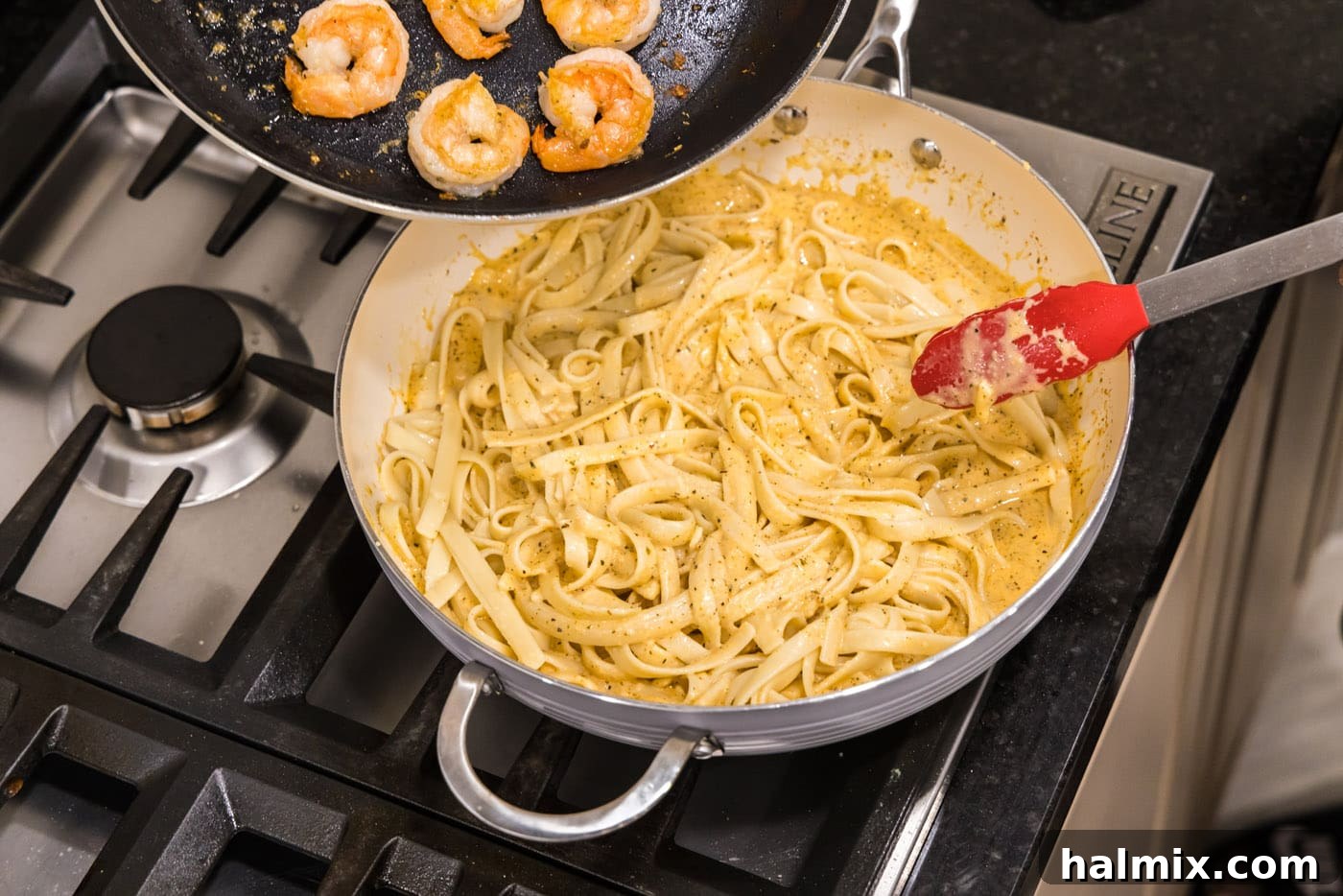 Creamy Garlic Shrimp Alfredo 13 Sautéed shrimp being added to the fettuccine and Alfredo sauce in a skillet, completing the dish.