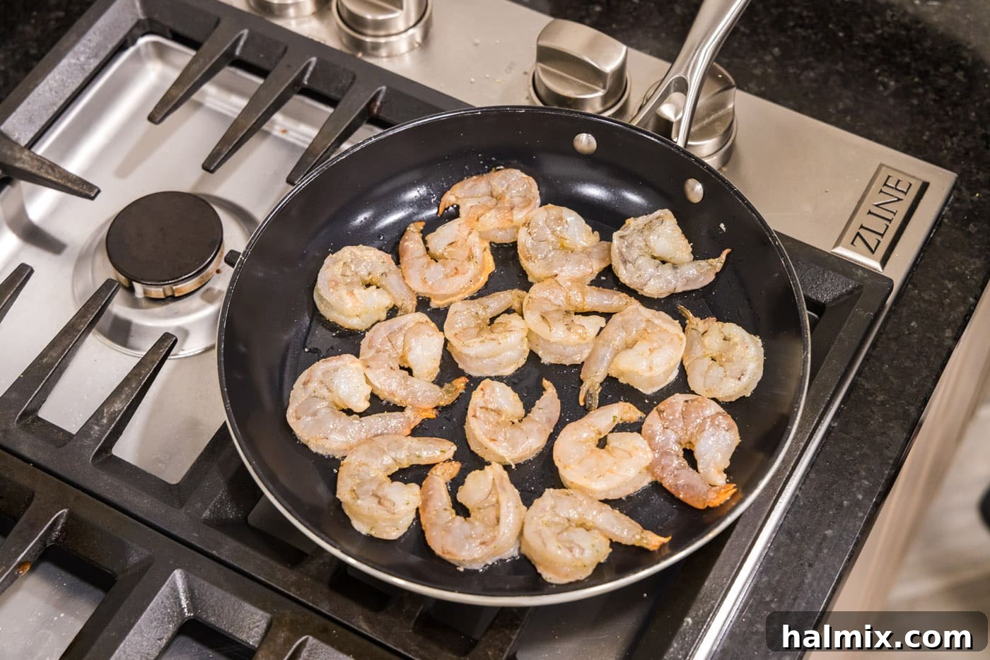 Creamy Garlic Shrimp Alfredo 6 Shrimp sizzling in a hot skillet, turning pink as they cook.