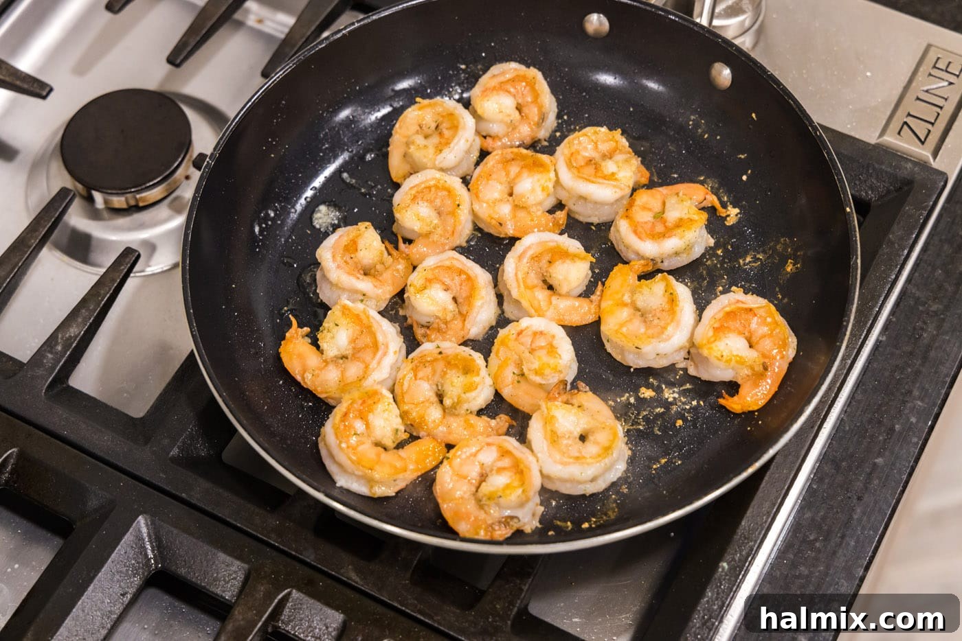 Creamy Garlic Shrimp Alfredo 7 Cooked shrimp, golden and slightly curled, resting in a skillet after being perfectly sautéed.