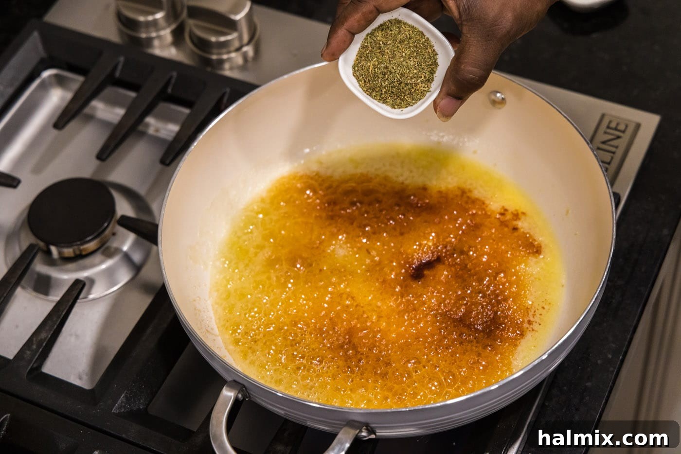 Creamy Garlic Shrimp Alfredo 8 A close-up view of butter melting in a skillet, with minced garlic, paprika, and Italian seasoning being added and stirred.