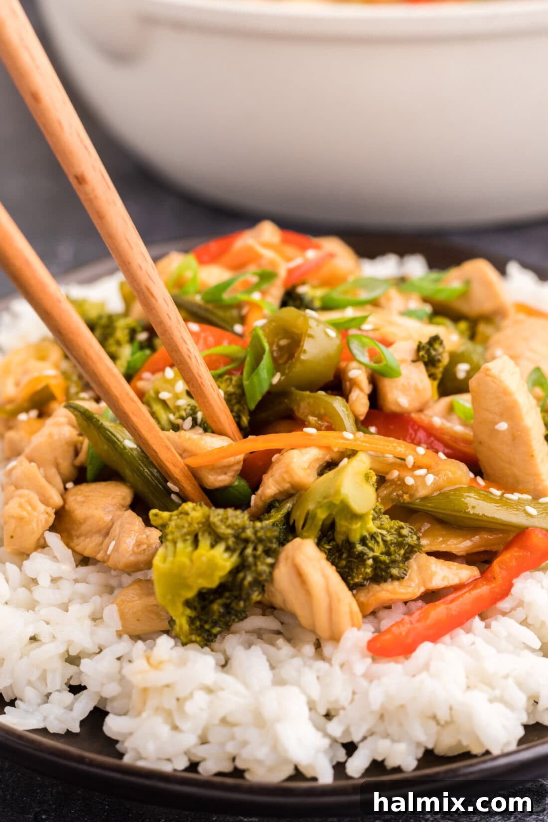 Close up photo of Honey Garlic Chicken Stir Fry on a plate over rice with chopsticks