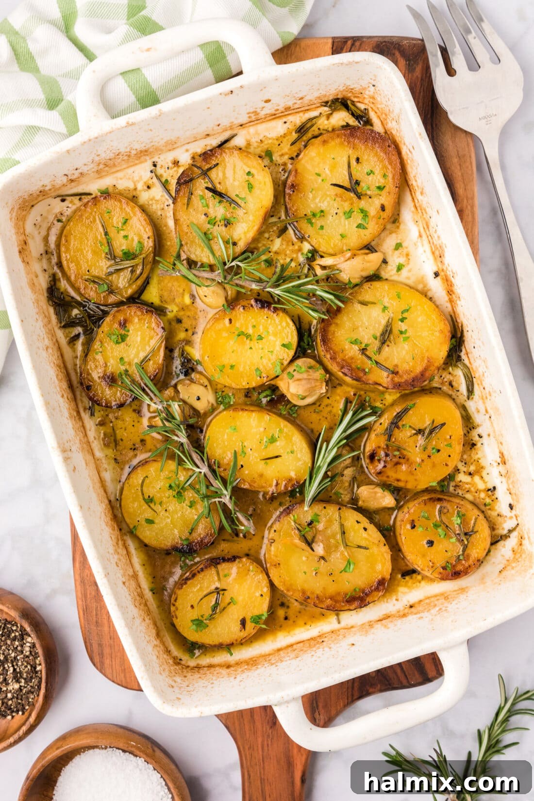 Melting Potatoes in a baking dish with rosemary garnish