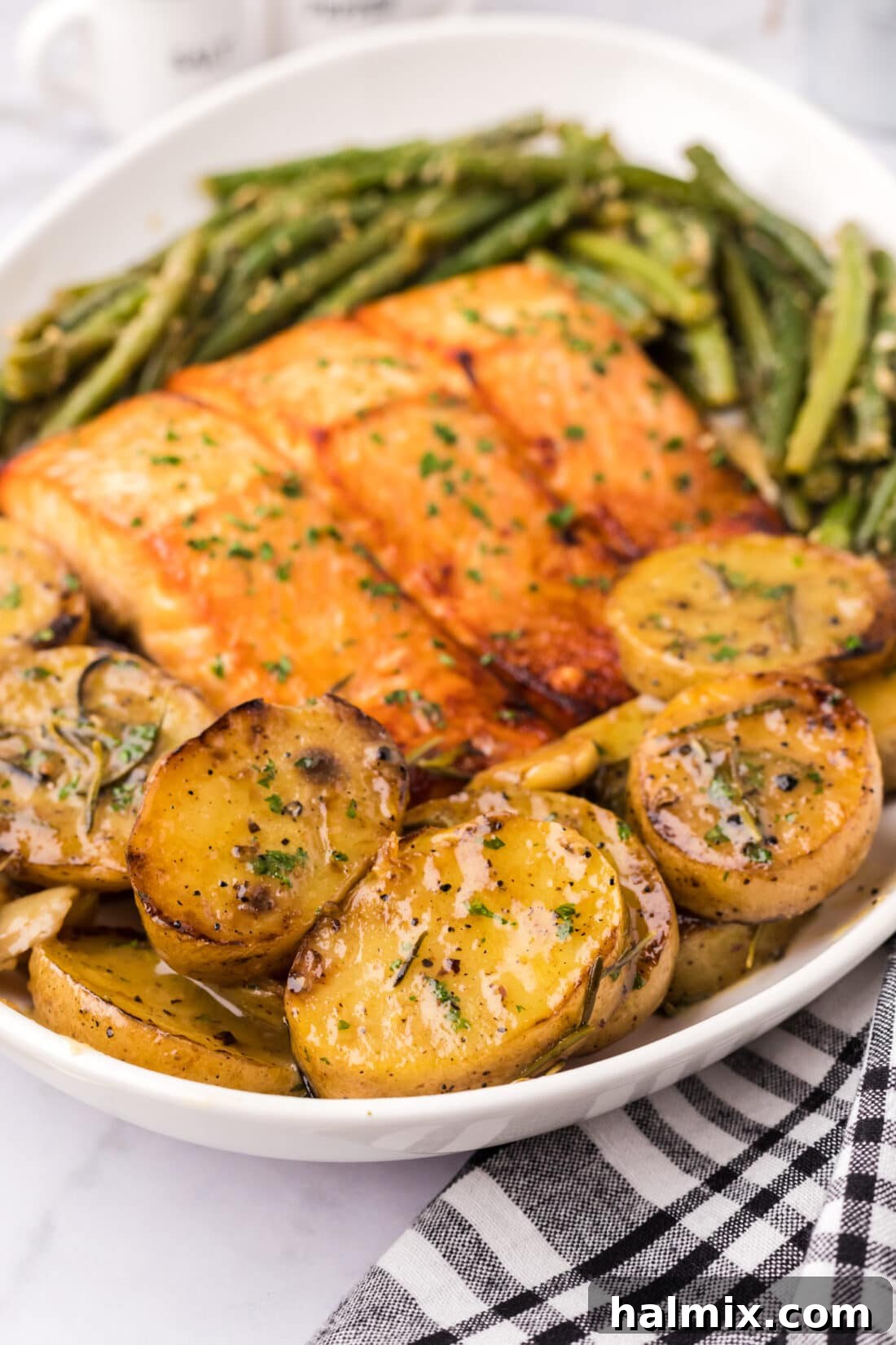 Melting Potatoes on a platter with garlic green beans and brown sugar salmon