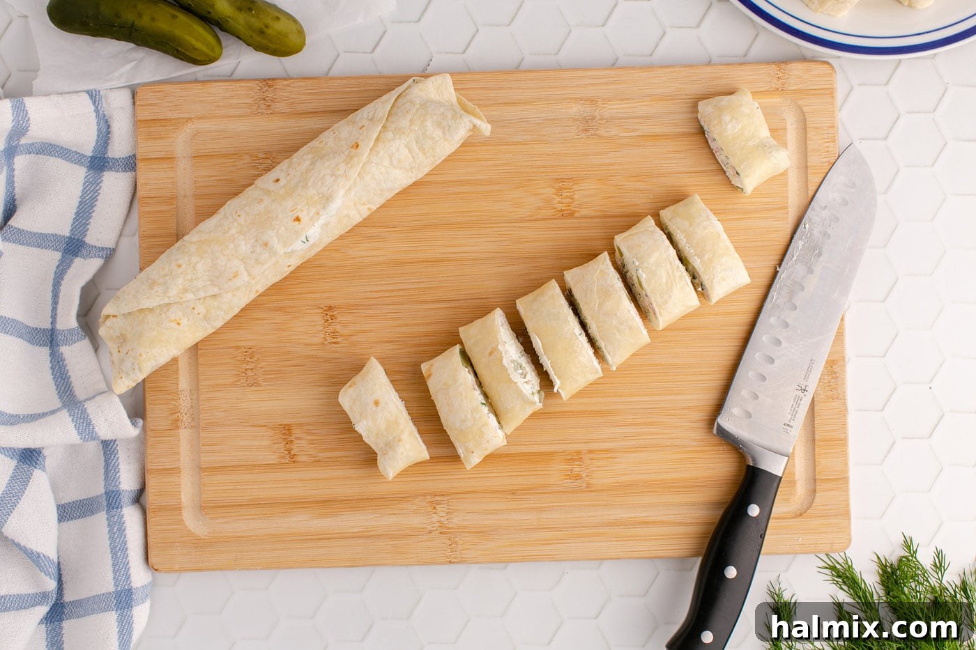 sliced dill pickle pinwheels on a cutting board