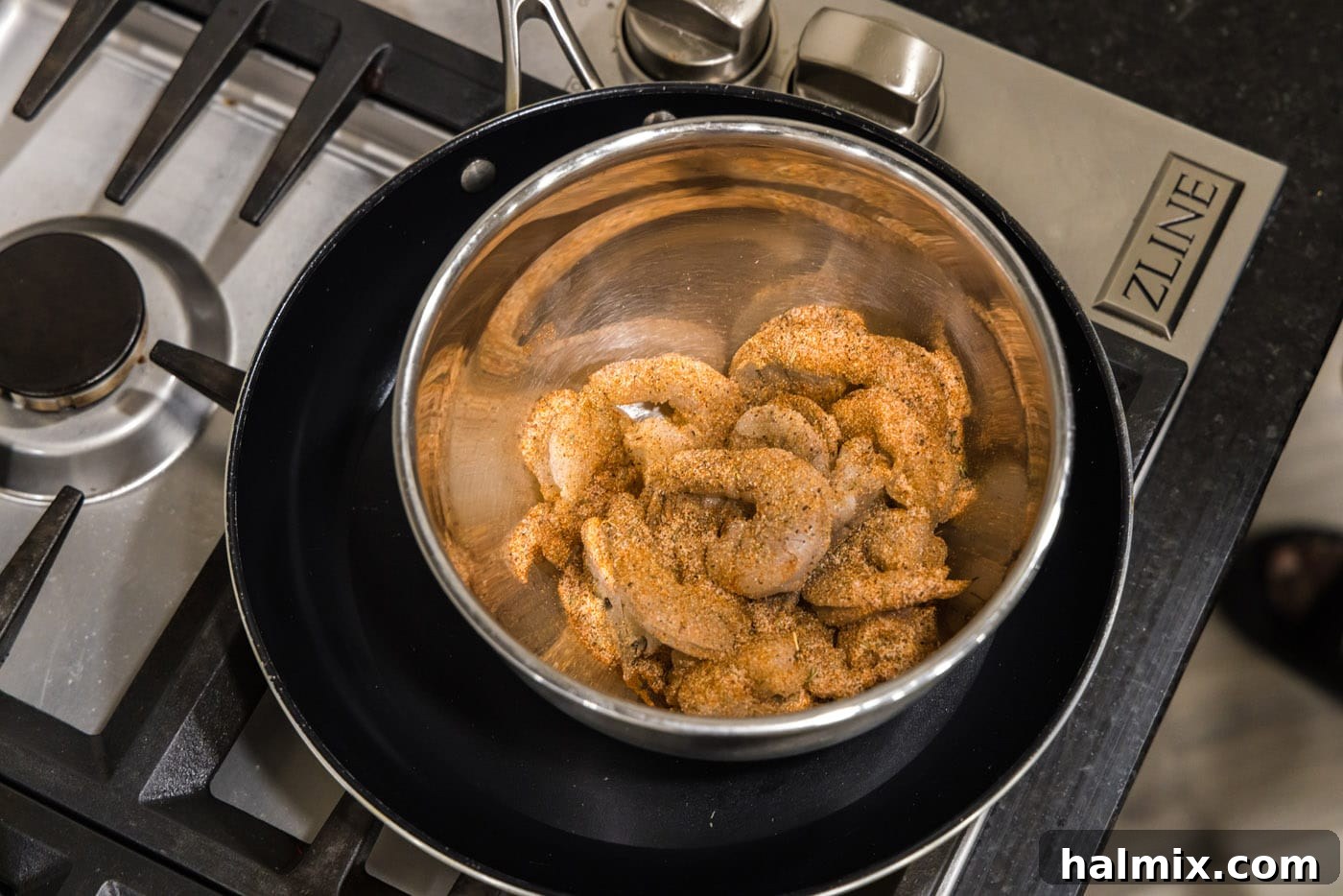 Cajun seasoned shrimp in a mixing bowl, showing the even spice coating before cooking.