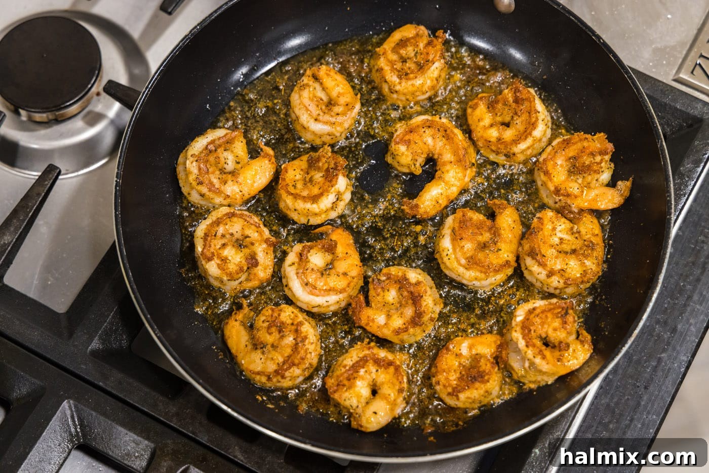 Perfectly cooked Cajun shrimp in a skillet, displaying the beautiful pink and red hues.