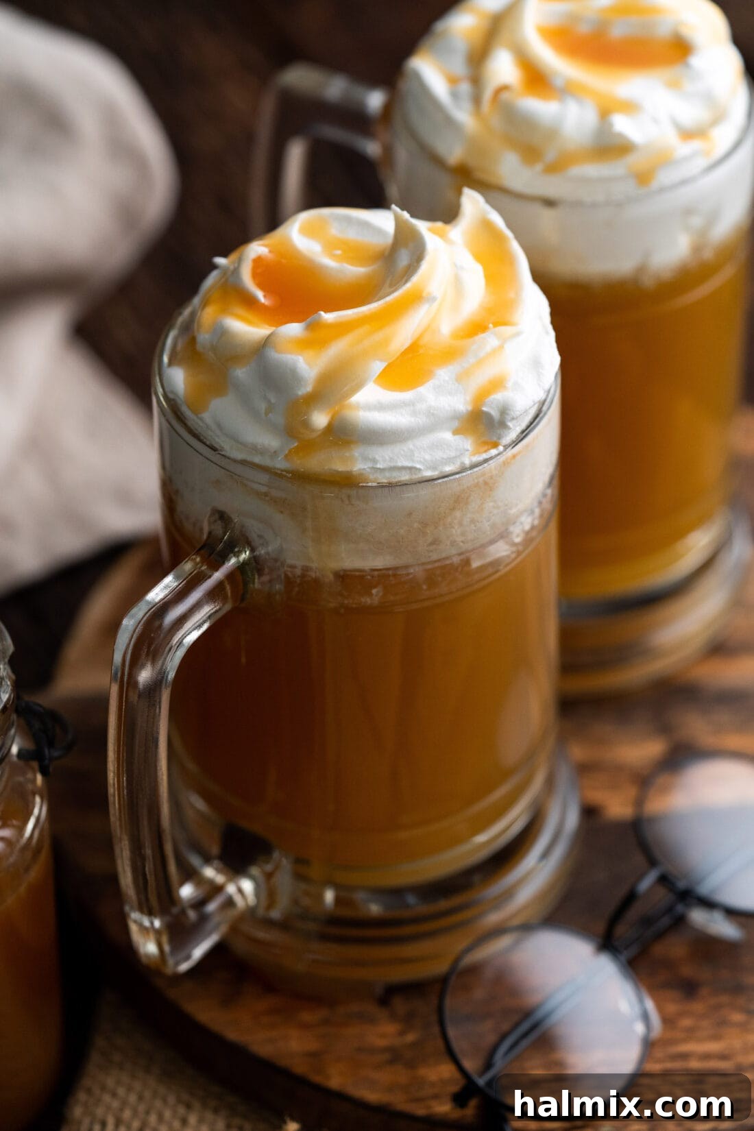 Two glasses of Butterbeer, a sweet and creamy butterscotch beverage from the Harry Potter universe.