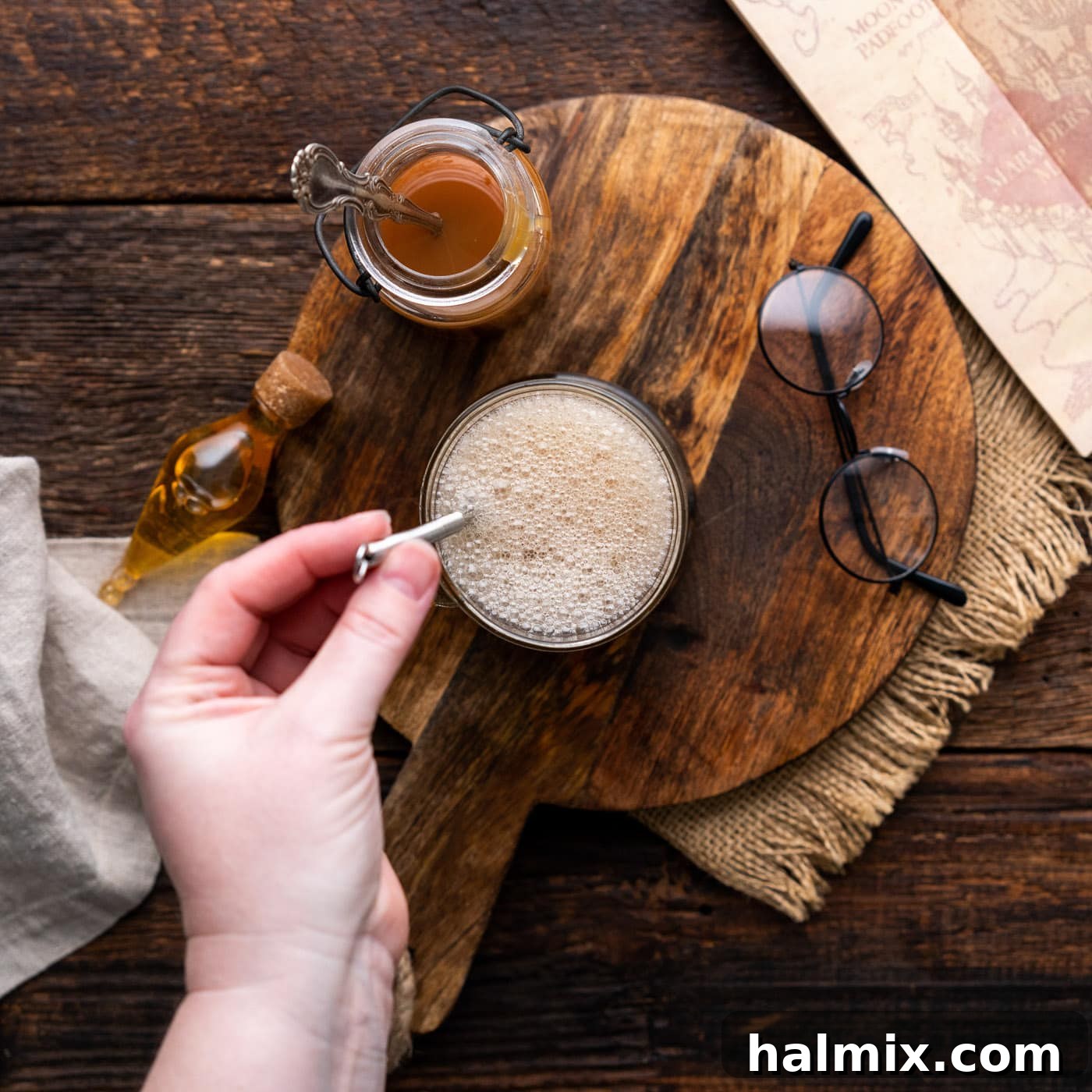An overhead view of the frothy, golden butterbeer mixture in a mug, perfectly stirred and ready for its topping.