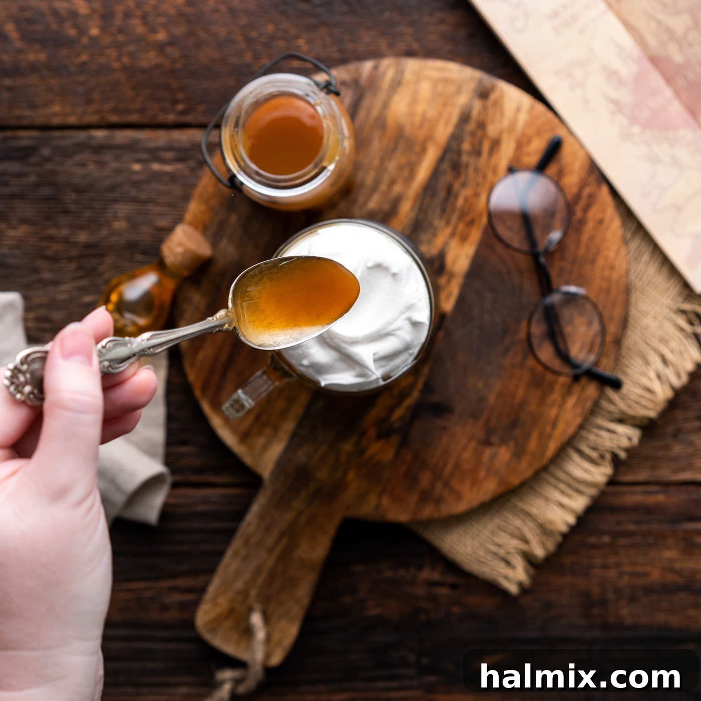A stream of butterscotch syrup drizzling over the whipped cream and butterbeer, completing the enchanting presentation.