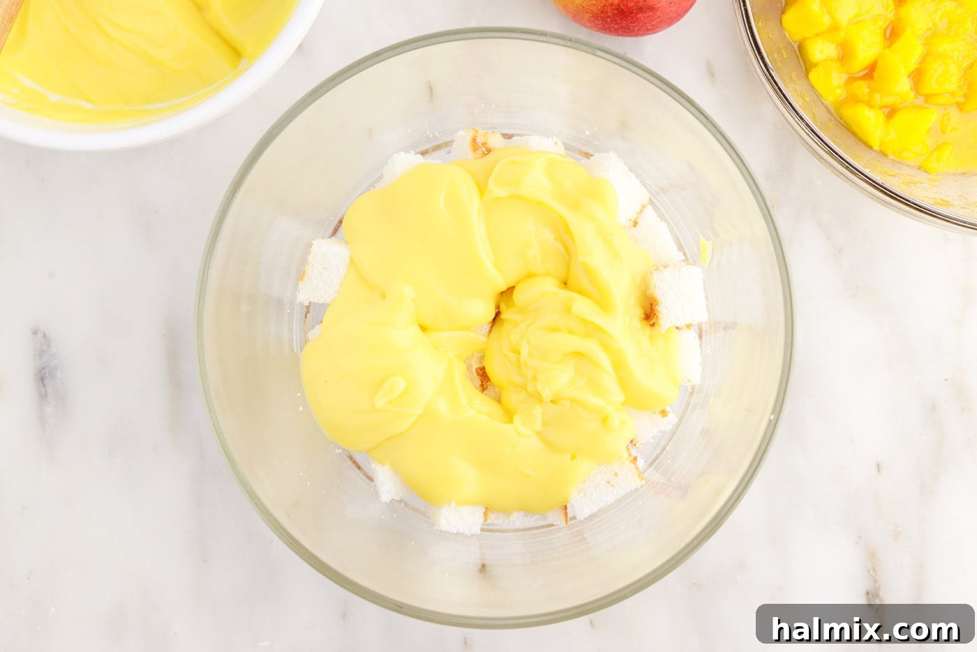 Vanilla pudding layer spread over angel food cake in a trifle dish