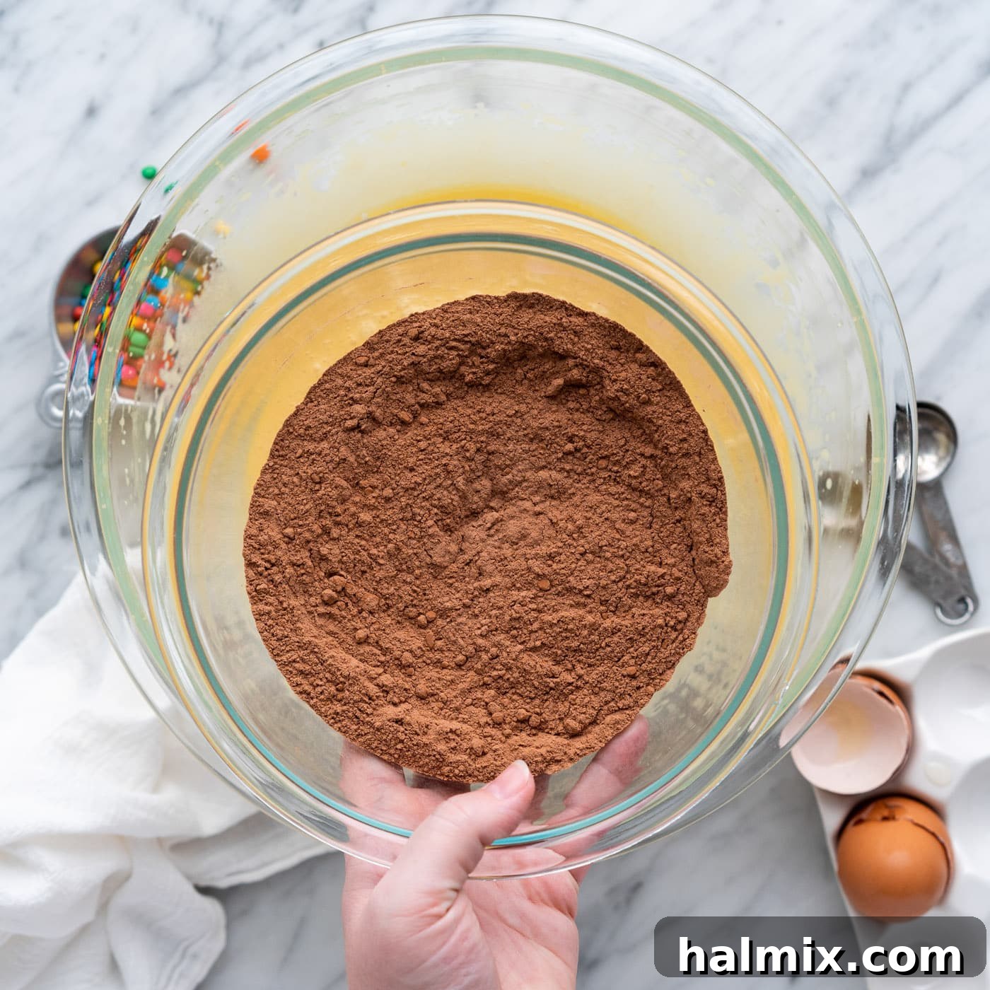 adding dry ingredients to wet ingredients for brownies, showing the start of combining