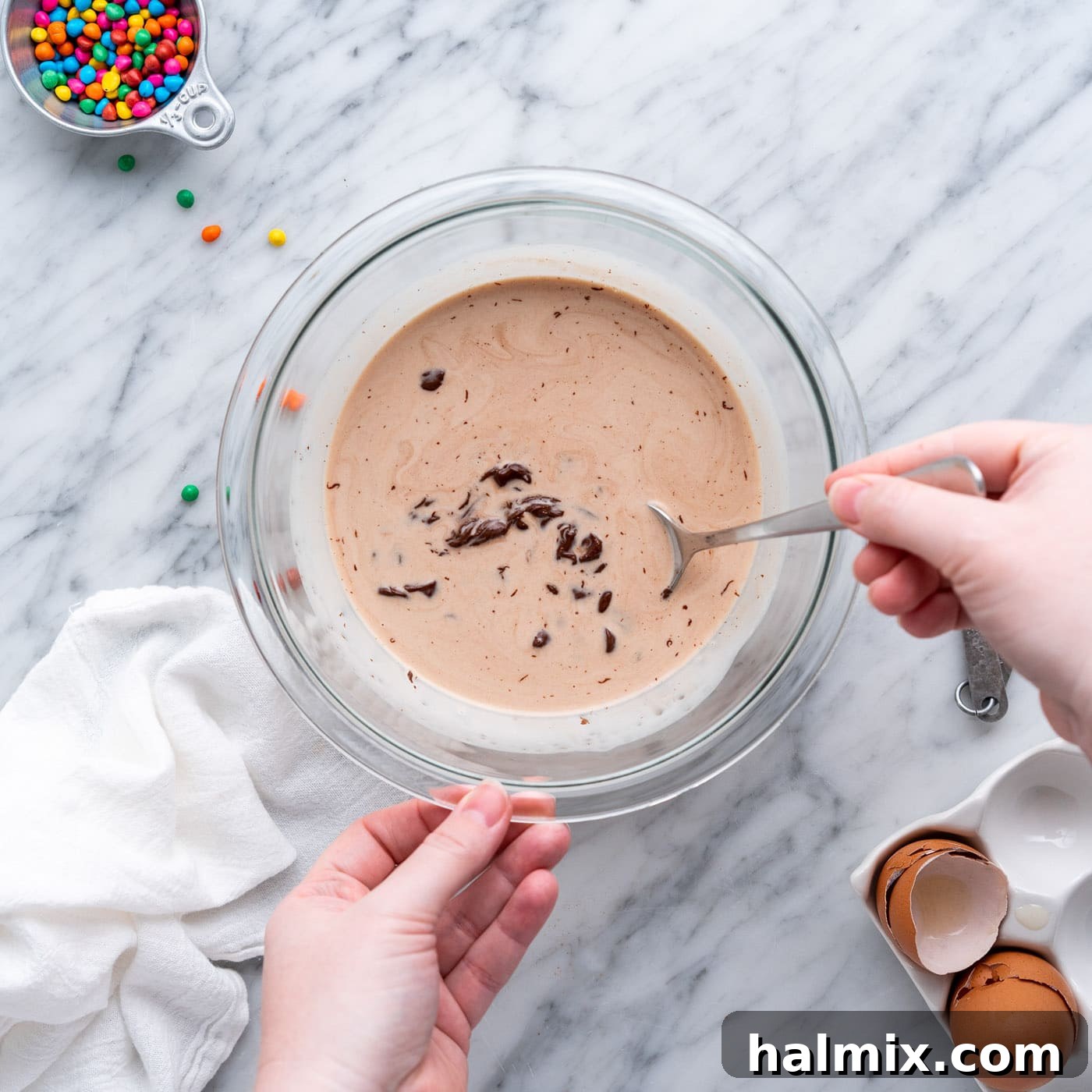 mixing chocolate chips and heavy whipping cream with a spoon to create ganache