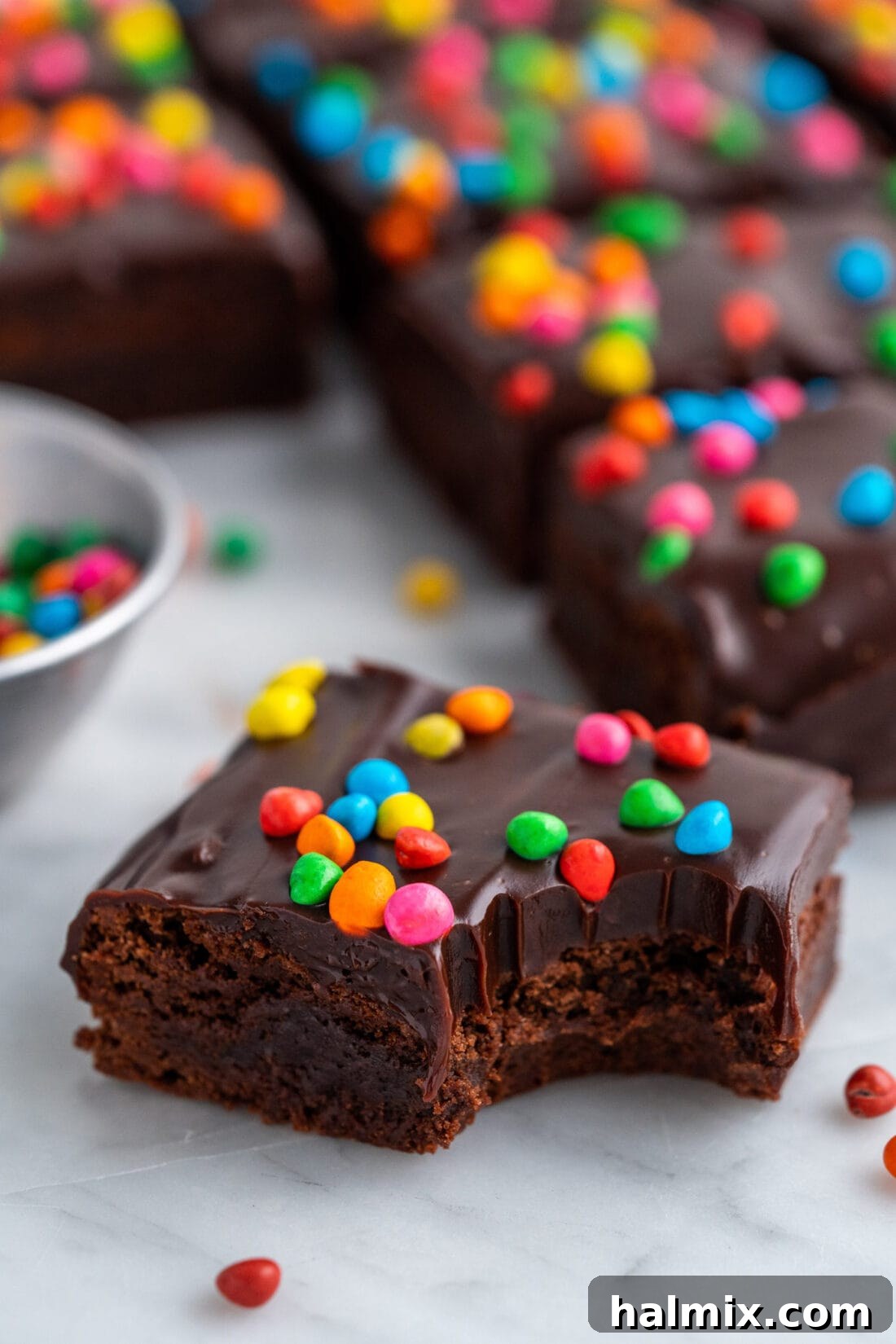 Close up photo of a Homemade Cosmic Brownie with a bite taken out, showing the dense, fudgy texture.