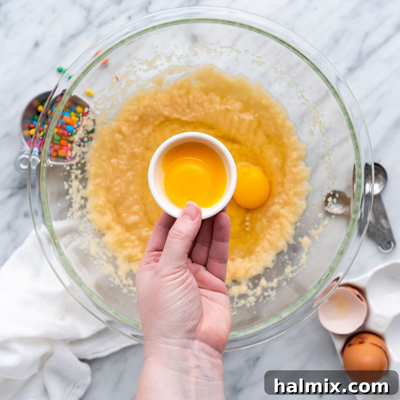 adding egg yolks to brownie batter, enriching the mixture