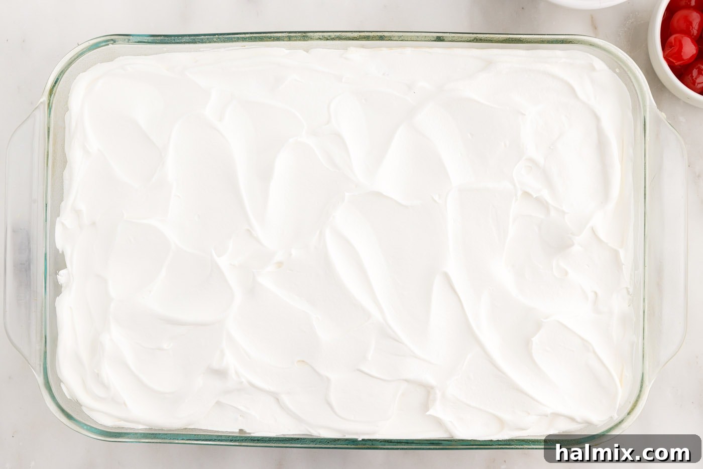 smooth cool whip frosting meticulously applied on top of the millionaire cake