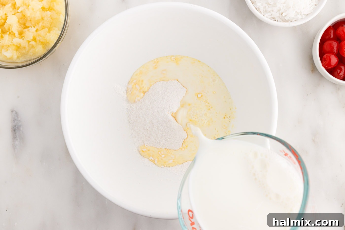 pouring milk into pudding mix in a bowl, ready to be whisked