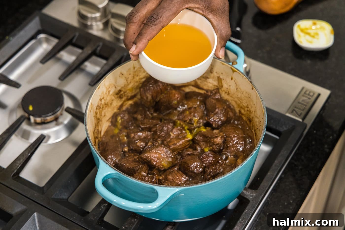 Savory Beef Bites in Velvety Gravy 9 adding chicken stock to beef tips in a pot