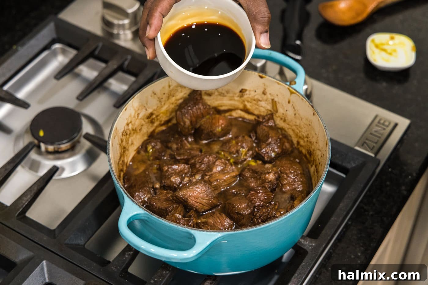 Savory Beef Bites in Velvety Gravy 10 pouring soy sauce into pot with beef tips