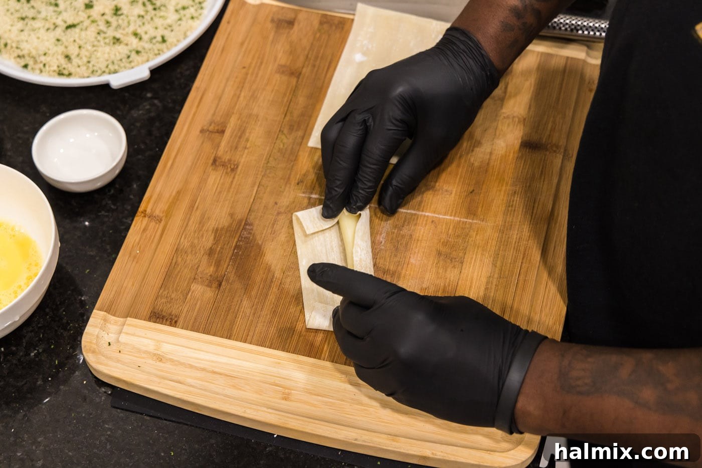 Crispy Wonton Cheese Bites 9 hands rolling a string cheese into an egg roll wrapper