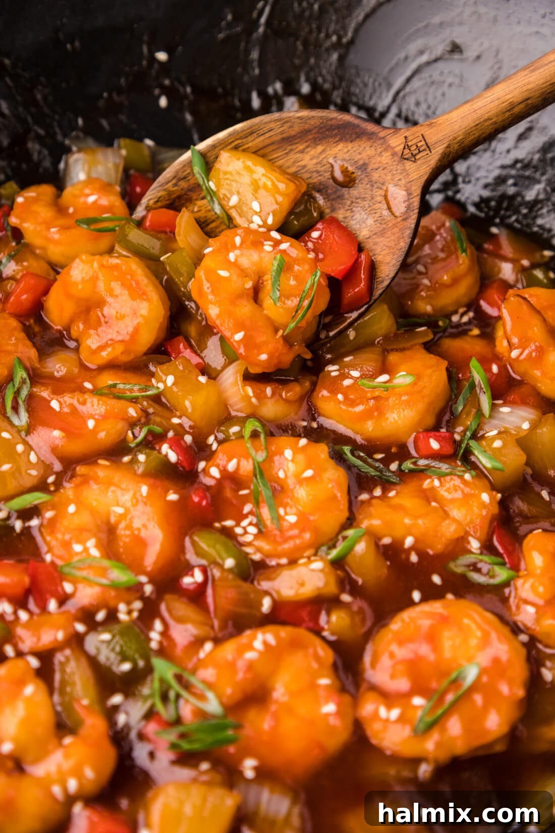 Close up photo of Sweet and Sour Shrimp in a wok with a spoon