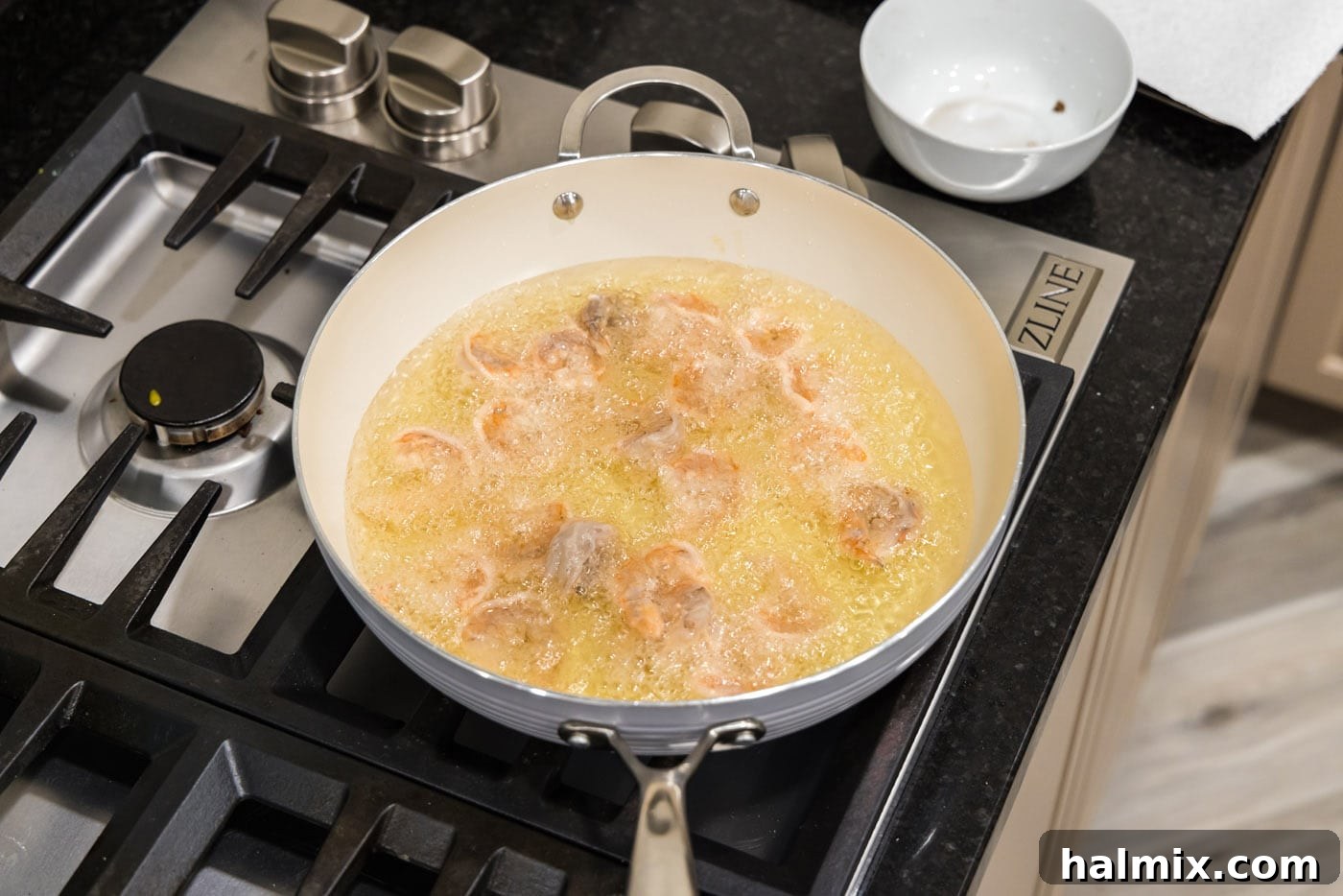 deep frying shrimp in a skillet of oil