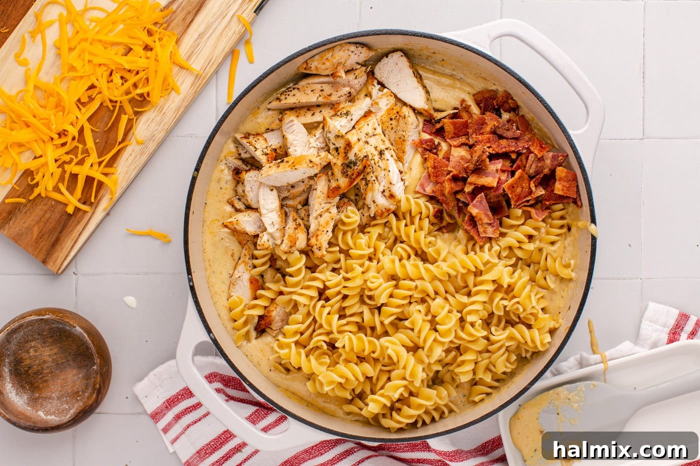 Cooked bacon, diced chicken, and rotini pasta tossed into the creamy ranch sauce in the skillet.