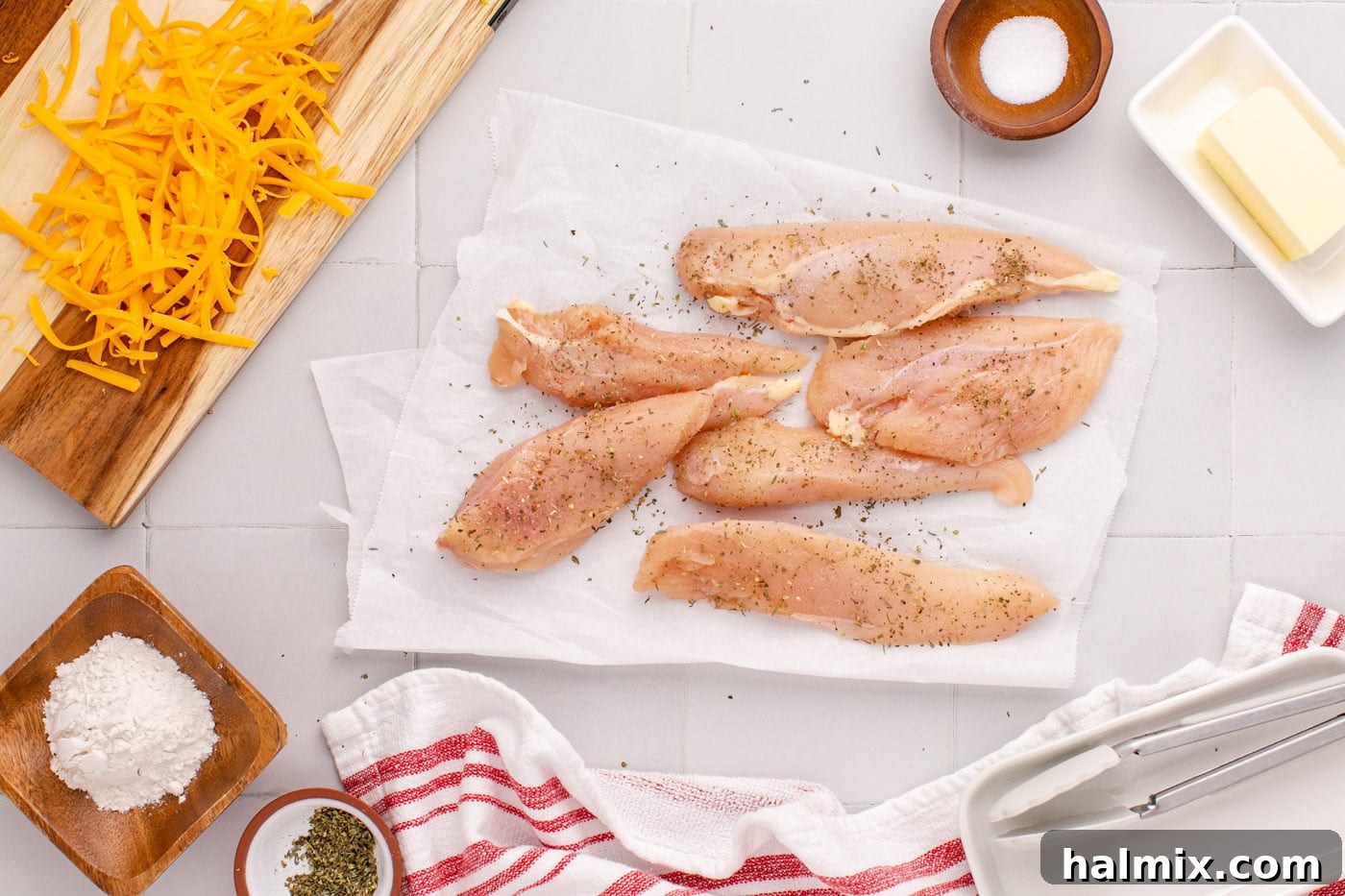 Seasoned chicken breasts ready for cooking, sprinkled with Italian seasoning and salt.