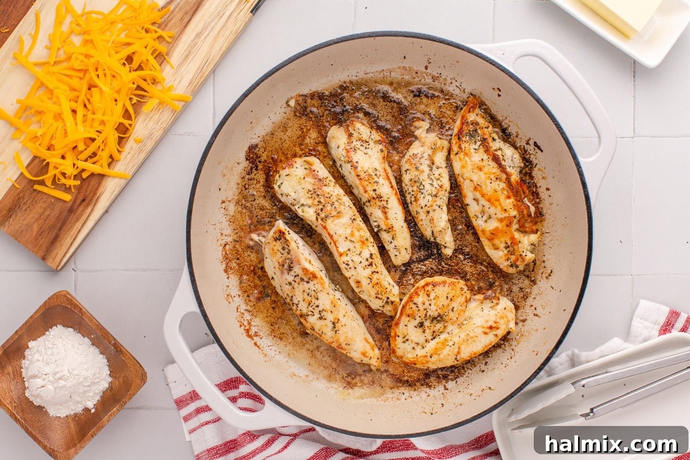 Perfectly pan-seared chicken breasts resting on a cutting board after cooking.