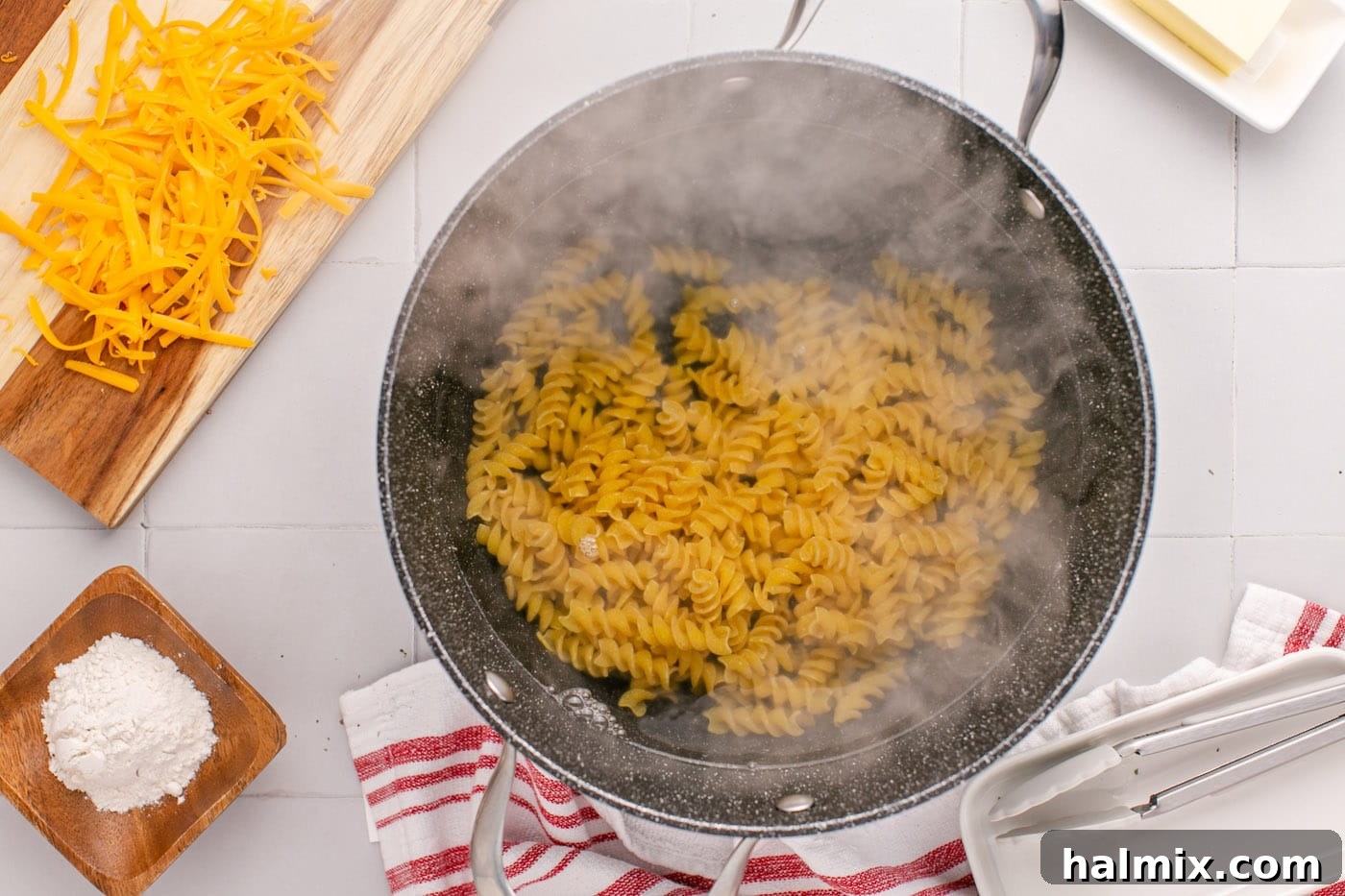 Rotini noodles boiling in a large pot of salted water on the stovetop.