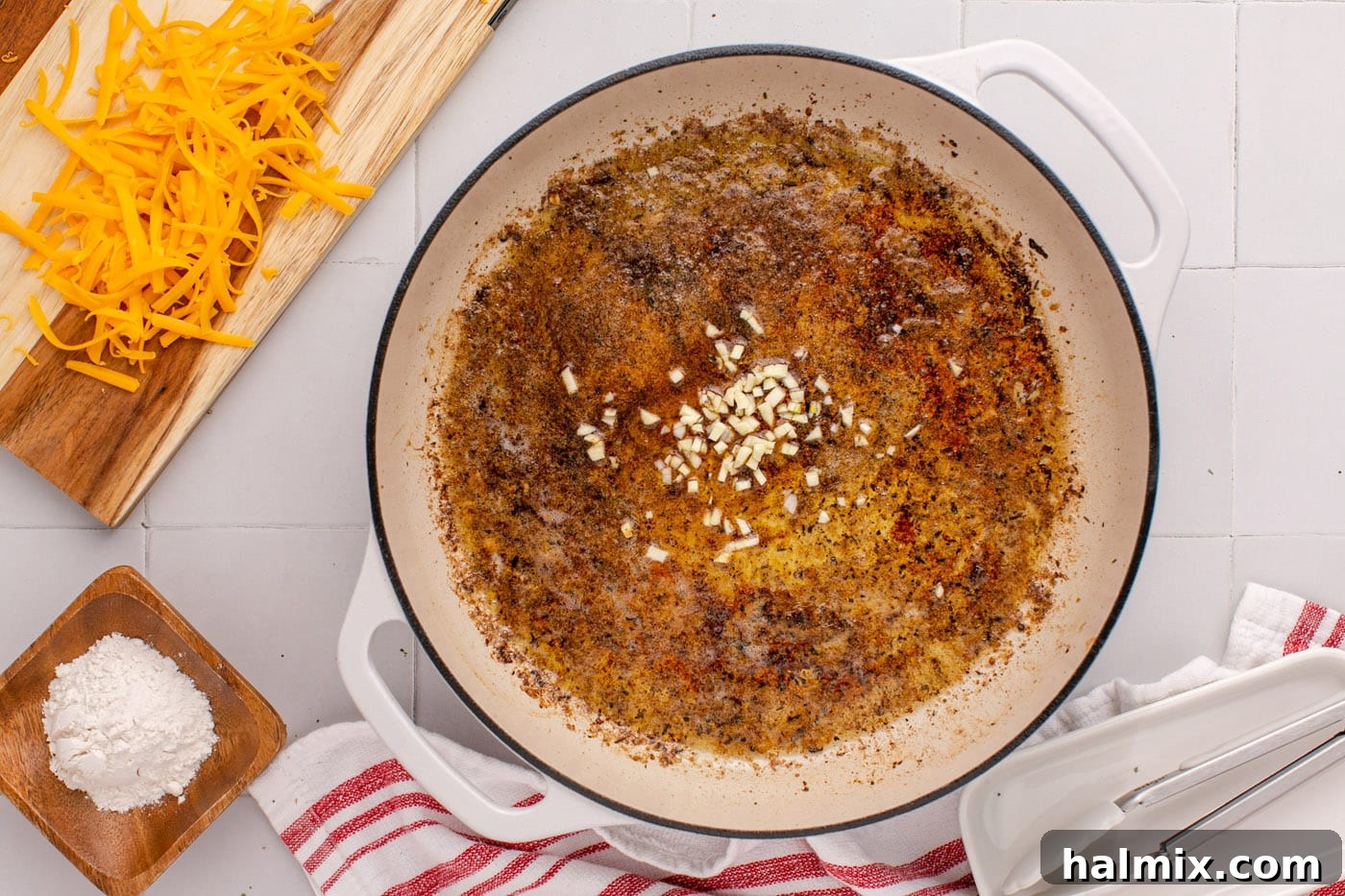 Minced garlic sautéing in melted butter and chicken drippings, becoming fragrant.