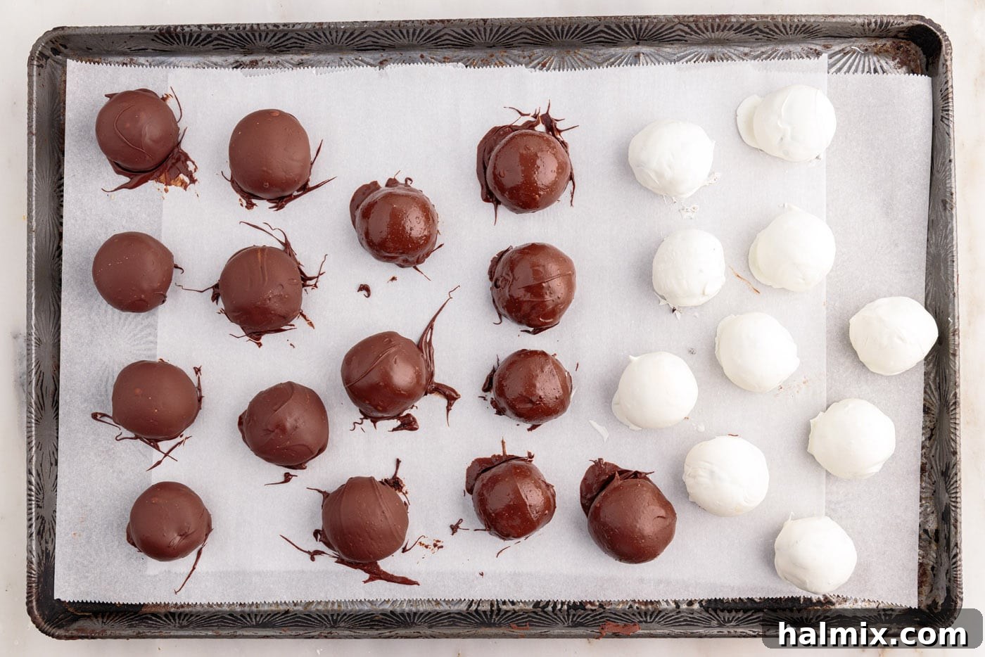 chocolate dipped oreo balls on a baking sheet, ready for decoration