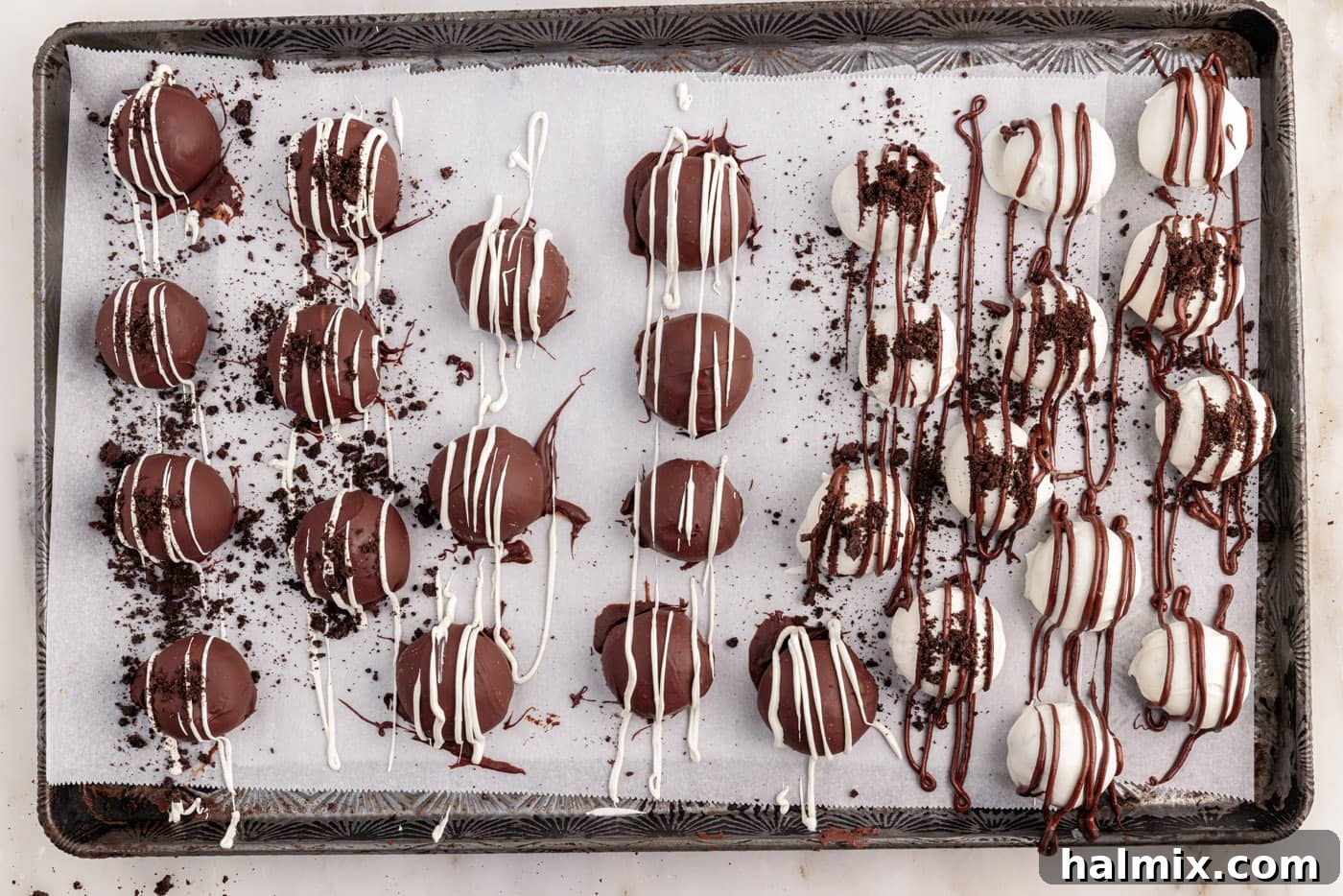drizzled and decorated oreo truffles on a baking sheet, showcasing the finished product