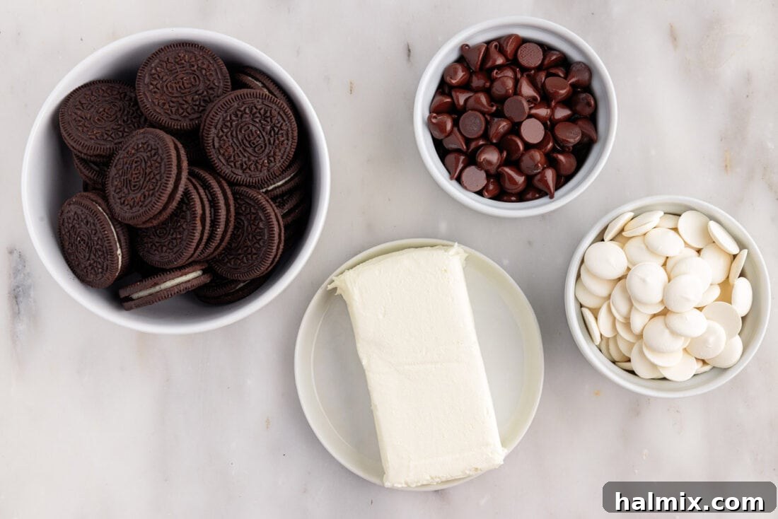Ingredients for Oreo Truffles laid out on a marble counter: Oreo cookies, cream cheese, white chocolate melts, and semi-sweet chocolate melts.