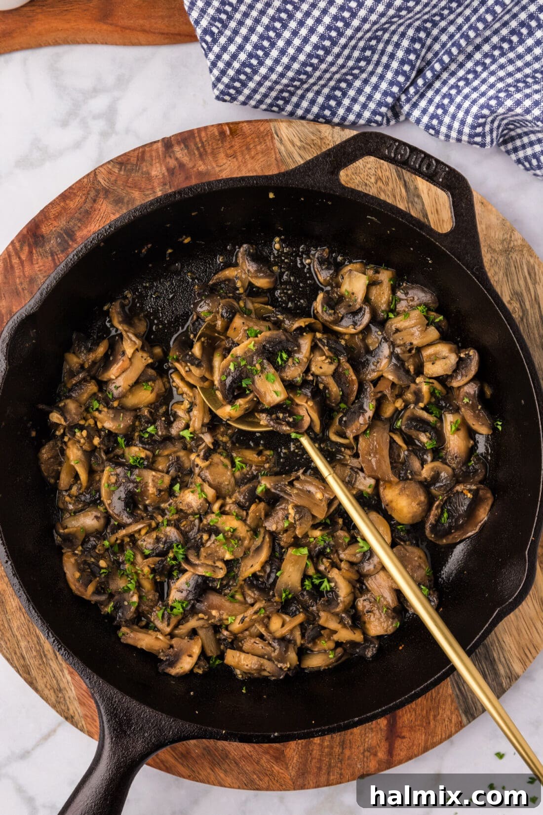 A cast iron skillet filled with perfectly golden-brown Sauteed Mushrooms, ready to serve.